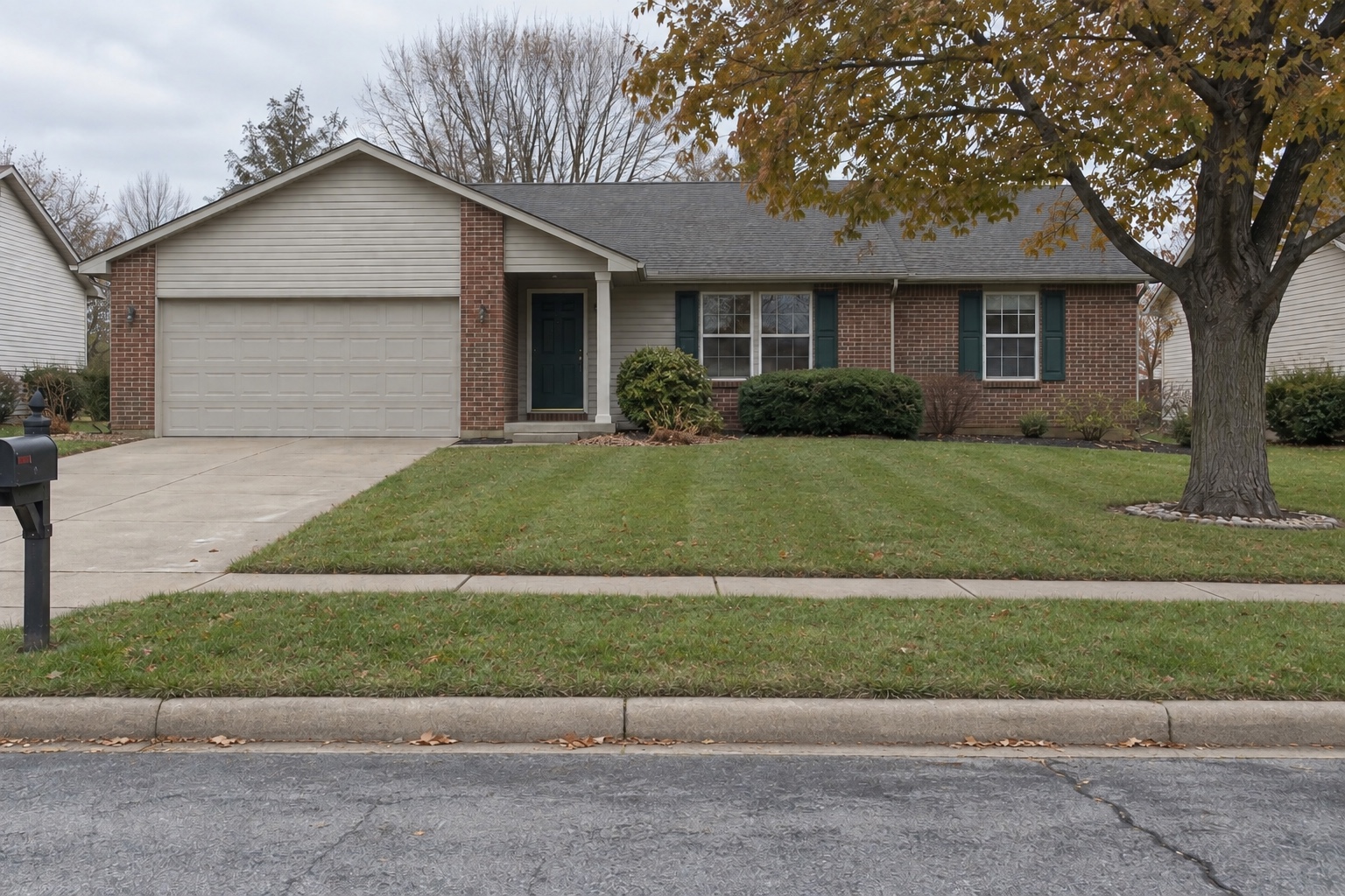 Later matched view of the same property with freshly mowed grass, a swept sidewalk and curb, fewer leaves, and no visible fallen branch